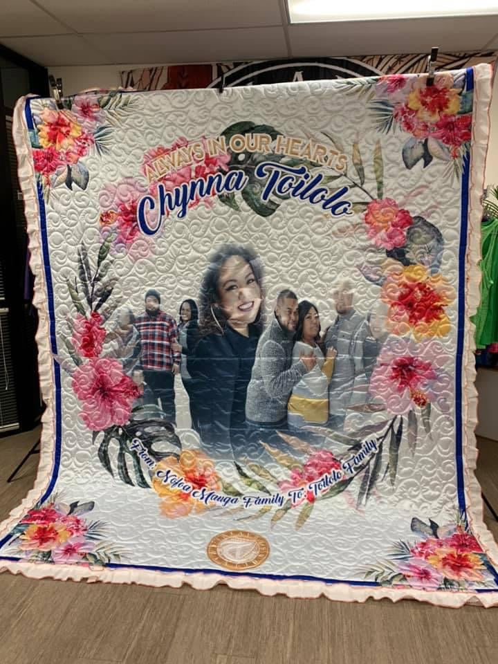 Finished floral family picture quilt displayed on a wall